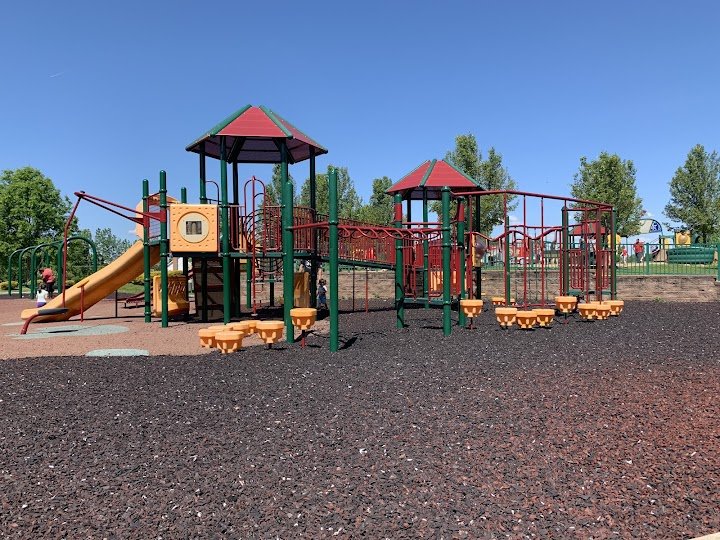 A colourful playground structure in a neighbourhood park on a sunny day